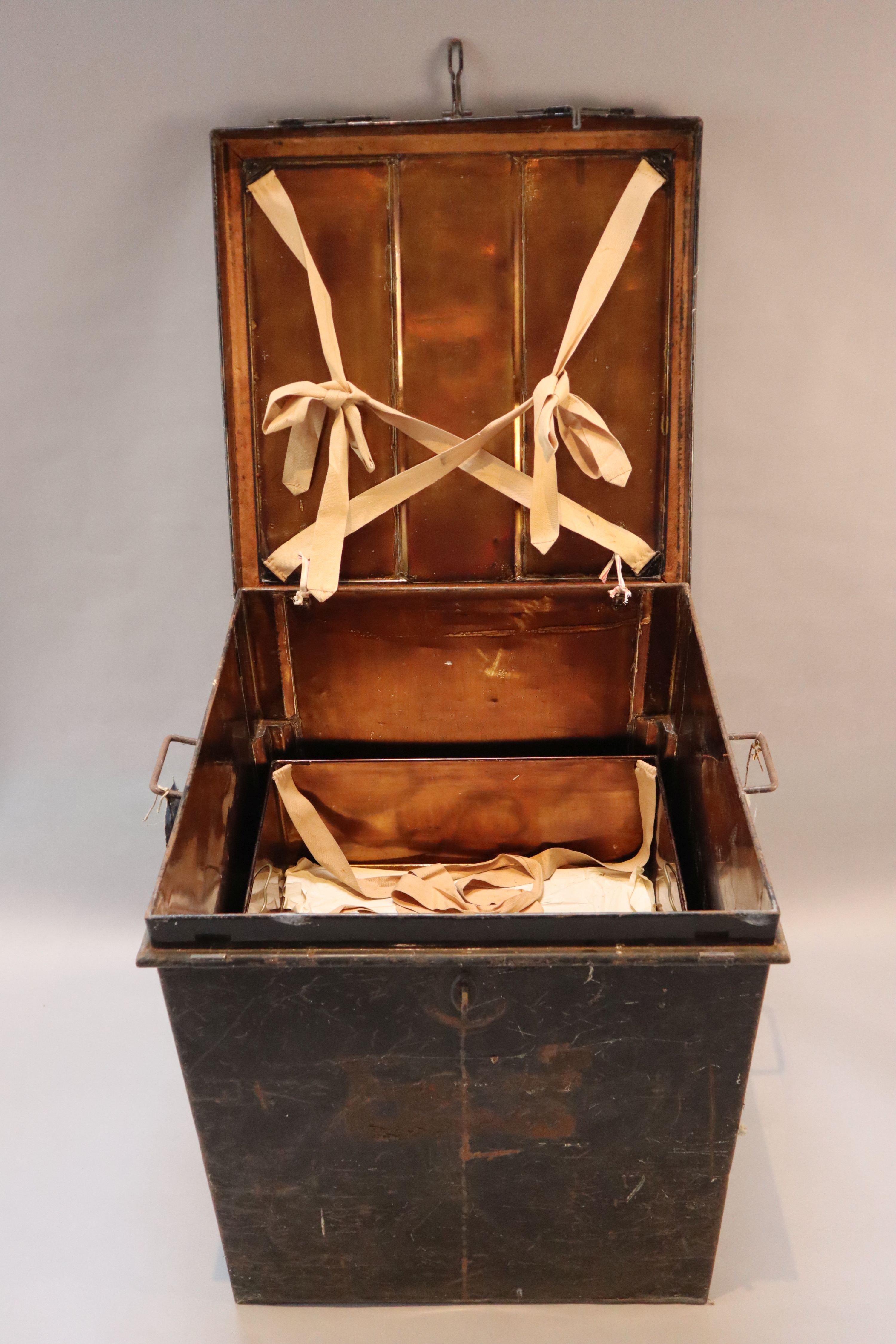 An early 20th century black painted tin travelling trunk, inscribed Lady Brabourne with old British India and Cooks Travel labels, wi